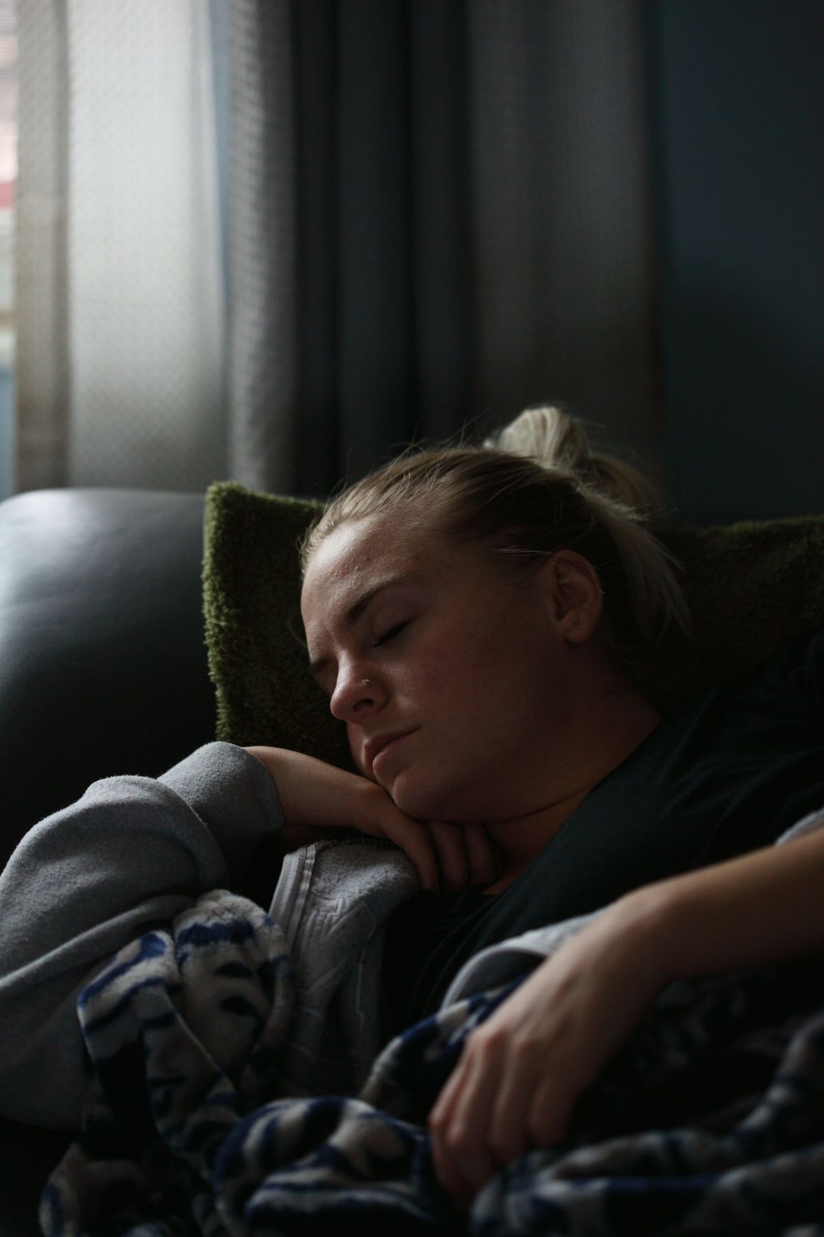 Trott person hviler under teppe i sofaen